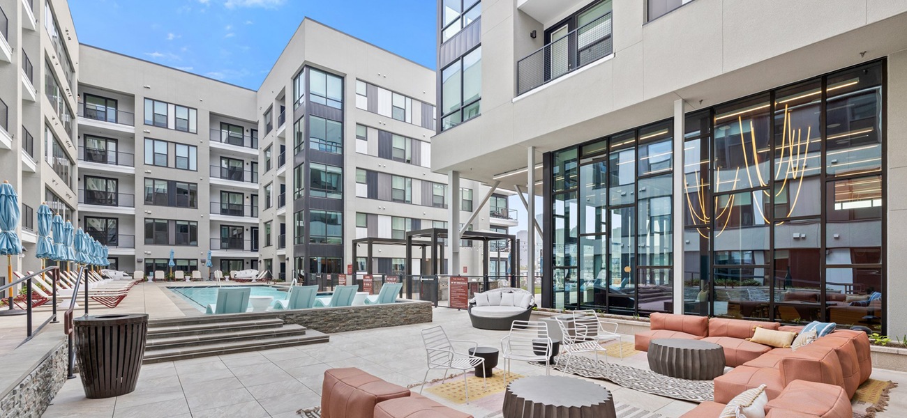 Spacious sparkling swimming pool with a large pool deck and cabanas for lounging